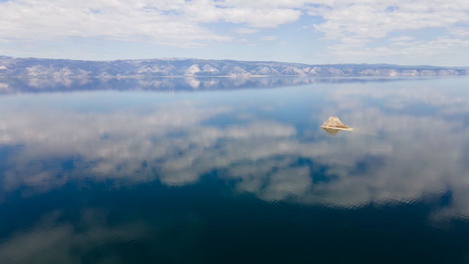 A serene aerial shot showcasing the calm waters and reflections of Lake Baikal in Russia.